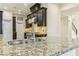 Close up of a kitchen island with granite countertops and stainless steel fixtures at 9044 Opus Dr, Las Vegas, NV 89117