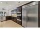 Gourmet kitchen with stainless steel appliances, dark wood cabinets, and tiled backsplash at 9044 Opus Dr, Las Vegas, NV 89117