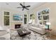 Cozy living room with fireplace, large windows, and comfortable seating at 9044 Opus Dr, Las Vegas, NV 89117
