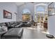Bright living room featuring a vaulted ceiling, large windows, and comfortable seating at 9417 Grenville Ave, Las Vegas, NV 89134