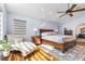 Sunlit main bedroom with a chaise lounge, ceiling fan, and light hardwood floors at 9417 Grenville Ave, Las Vegas, NV 89134