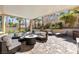 Comfortable covered patio with cushioned seating, brick pavers, landscaping, and beautiful backyard in a desert climate at 9417 Grenville Ave, Las Vegas, NV 89134