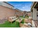 Cozy backyard featuring artificial turf, a playhouse, and a comfortable seating area for relaxing and entertaining at 9835 Fox Estate St, Las Vegas, NV 89141