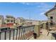 Balcony view showcasing neighborhood homes, black metal railings, and inviting outdoor seating at 9835 Fox Estate St, Las Vegas, NV 89141