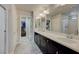 Bright bathroom features a double sink vanity with a modern countertop and a large mirror at 9835 Fox Estate St, Las Vegas, NV 89141
