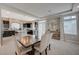 Open-concept living with dining area flowing into a modern kitchen featuring black cabinets and a center island at 9835 Fox Estate St, Las Vegas, NV 89141