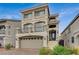 Beautiful three-story home with a two-car garage, balcony, and stylish architectural details at 9835 Fox Estate St, Las Vegas, NV 89141