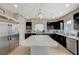 Spacious kitchen featuring stainless steel appliances, dark wood cabinetry, and a large island at 9835 Fox Estate St, Las Vegas, NV 89141