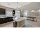 Modern kitchen with dark cabinets, stainless steel appliances, and a large island; dining area nearby at 9835 Fox Estate St, Las Vegas, NV 89141