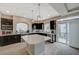 Contemporary kitchen featuring black cabinets, stainless steel appliances, and a spacious center island at 9835 Fox Estate St, Las Vegas, NV 89141