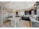 A modern kitchen with stainless steel appliances, dark cabinets, light countertops, and a large center island at 9835 Fox Estate St, Las Vegas, NV 89141