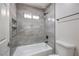 Clean bathroom with modern gray tile, a tub, shower combination, and recessed shelving for convenient storage at , Las Vegas, NV 89118