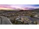 Aerial view of home in desert community showcasing nearby mountain views and colorful sunset at 13 Scenic Terrain Ave, Henderson, NV 89011