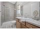Clean bathroom features a glass-enclosed shower, a wood vanity with stone counters, and modern finishes at 13 Scenic Terrain Ave, Henderson, NV 89011