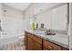 Bathroom featuring granite countertop, wood cabinets, and tiled shower/tub at 13 Scenic Terrain Ave, Henderson, NV 89011