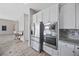 Modern kitchen featuring stainless steel appliances, white cabinetry, and granite countertops for cooking at 13 Scenic Terrain Ave, Henderson, NV 89011