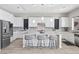 Modern kitchen boasts stainless steel appliances, granite counters, an island with seating, and white cabinetry at 13 Scenic Terrain Ave, Henderson, NV 89011