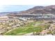 A scenic aerial shot captures the golf course community nestled amid lush trees and mountains at 1455 Macdonald Ranch Dr, Henderson, NV 89012