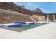 Stunning backyard pool features a hillside backdrop, an outdoor kitchen, and tranquil water features at 1455 Macdonald Ranch Dr, Henderson, NV 89012