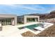 Expansive backyard pool area with modern home, outdoor kitchen, lush green turf, and a hillside backdrop at 1455 Macdonald Ranch Dr, Henderson, NV 89012