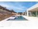 A backyard pool with an outdoor kitchen, mountain views, and modern landscaping at 1455 Macdonald Ranch Dr, Henderson, NV 89012