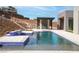Backyard swimming pool with blue tiled accents, an outdoor kitchen and a view of the hillside at 1455 Macdonald Ranch Dr, Henderson, NV 89012