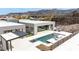 A modern home featuring a backyard pool with raised spa, covered outdoor kitchen and natural rock landscaping at 1455 Macdonald Ranch Dr, Henderson, NV 89012