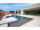 Relaxing backyard pool with an outdoor kitchen, large sliding glass doors, and modern architecture at 1455 Macdonald Ranch Dr, Henderson, NV 89012