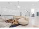 Modern living room with a round couch, glass table, stairs, and a marble floor at 1455 Macdonald Ranch Dr, Henderson, NV 89012