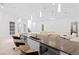 Long kitchen island with bar seating, with an open living room with modern white decor at 1455 Macdonald Ranch Dr, Henderson, NV 89012