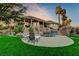 Backyard view with a pool, rock waterfall feature, and a covered patio seating area at 1700 Brock Ct, Las Vegas, NV 89117