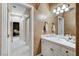 Well-lit bathroom features a single sink, white cabinets, and tiled countertop with views to hall and bedroom at 1700 Brock Ct, Las Vegas, NV 89117