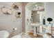 Stylish powder room with pedestal sink, decorative mirror, and elegant fixtures at 1700 Brock Ct, Las Vegas, NV 89117