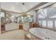 Lavish bathroom with a large jetted tub, dual vanities, decorative lighting, and a large window at 1700 Brock Ct, Las Vegas, NV 89117