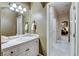 Well-lit bathroom features a single sink, white cabinets, and tiled countertop with views to hall and bedroom at 1700 Brock Ct, Las Vegas, NV 89117