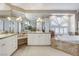 An opulent bathroom features dual vanities, ample mirror space, large windows, and a jetted tub at 1700 Brock Ct, Las Vegas, NV 89117