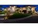 Night view of an elegant home with manicured lawn, landscape lighting and lush landscaping at 1700 Brock Ct, Las Vegas, NV 89117