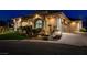Exterior elevation of an elegant house with a manicured lawn, rock features, and a three-car garage at 1700 Brock Ct, Las Vegas, NV 89117