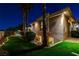 Night view of house exterior showing landscaped yard with decorative lighting and stucco wall at 1700 Brock Ct, Las Vegas, NV 89117