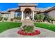 Exterior view of a home with an arched entryway, stone columns and a garden in the front at 1700 Brock Ct, Las Vegas, NV 89117