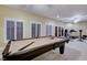 Spacious game room with a billiard table, workout equipment, and natural light from shuttered windows at 1700 Brock Ct, Las Vegas, NV 89117