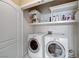 Well-equipped laundry room with a washer, dryer, storage shelves, and a white door at 1700 Brock Ct, Las Vegas, NV 89117