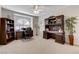 A home office features dark wood desks and cabinets, ample natural light, and neutral carpeting at 1700 Brock Ct, Las Vegas, NV 89117