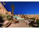 Landscaped backyard featuring a pool with rock features, waterfall, and patio furniture at 1700 Brock Ct, Las Vegas, NV 89117