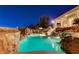 Sparkling pool with waterfall and slide features and lounge area, illuminated at twilight at 1700 Brock Ct, Las Vegas, NV 89117
