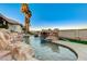 Resort-style pool featuring rock waterfall elements and well-maintained artificial turf at 1700 Brock Ct, Las Vegas, NV 89117