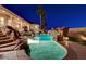 Backyard pool with slide and waterfall features, surrounded by rock landscaping and palm trees at 1700 Brock Ct, Las Vegas, NV 89117