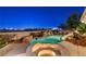 Inviting pool with rock features, waterfall, spa and outdoor seating at twilight at 1700 Brock Ct, Las Vegas, NV 89117