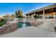 Backyard featuring a custom pool with rock features, spa, and a water slide at 1700 Brock Ct, Las Vegas, NV 89117