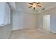 Carpeted bedroom featuring a ceiling fan and bright natural light from large window at 23 E Agate Ave # 303, Las Vegas, NV 89123